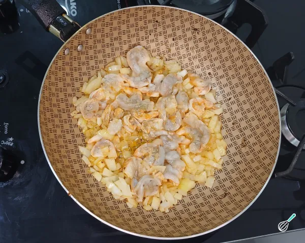Refogando camarões e cebola na panela
