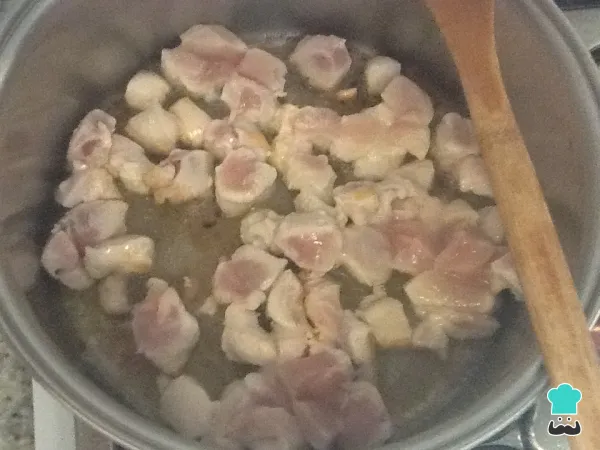Cubos de peito de frango cozinhando em molho na panela